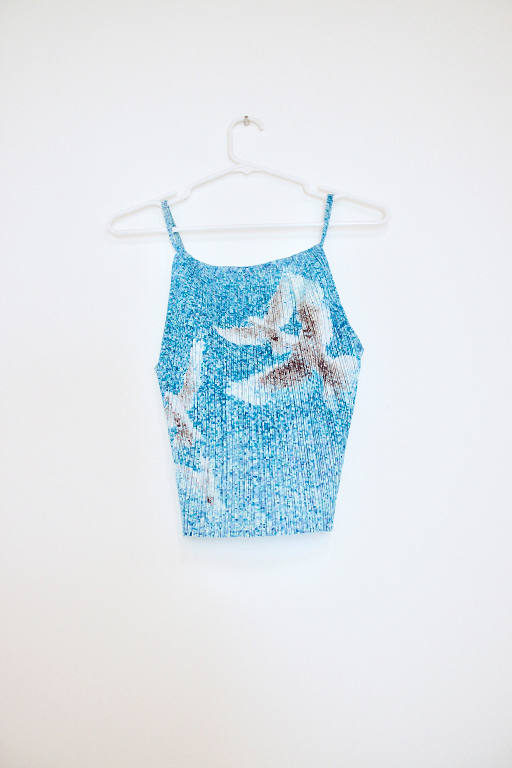 A pleated tank top with a photographic print of doves flying on it